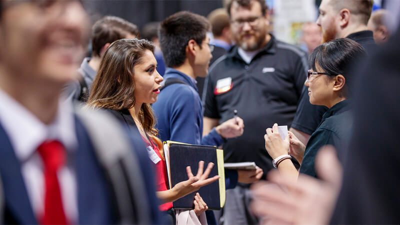 Students talking to employers at career fair