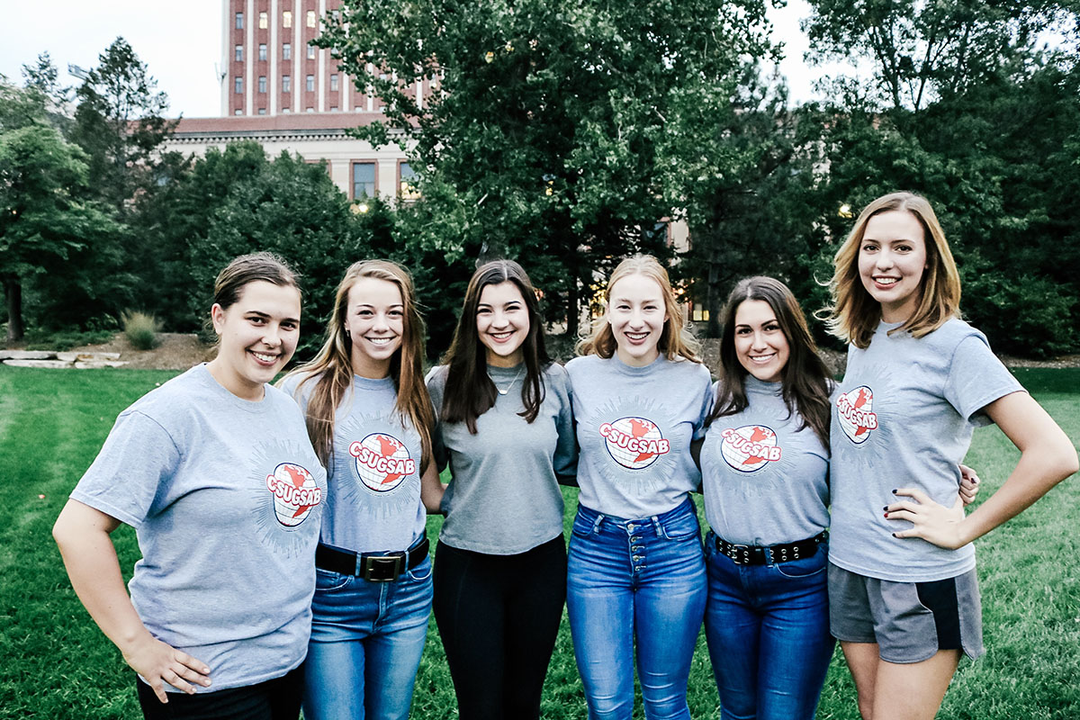 6 women communication studies advisory board members standing in a line outside of oldfather.