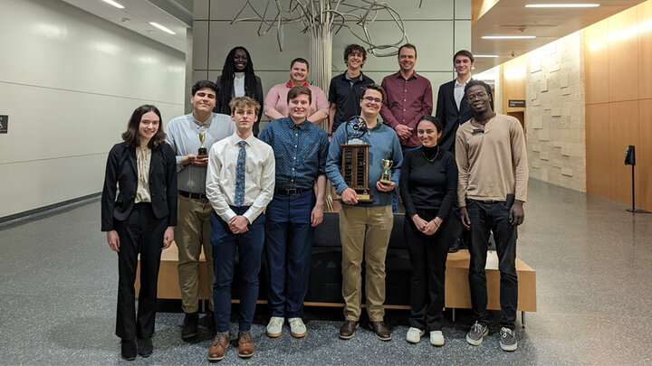 Debate group members with trophies