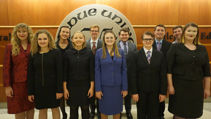 The UNL Speech and Debate team posing for a group photo in hallway at Purdue University 