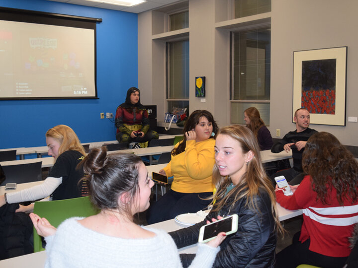 Students in a classroom talking to each other.